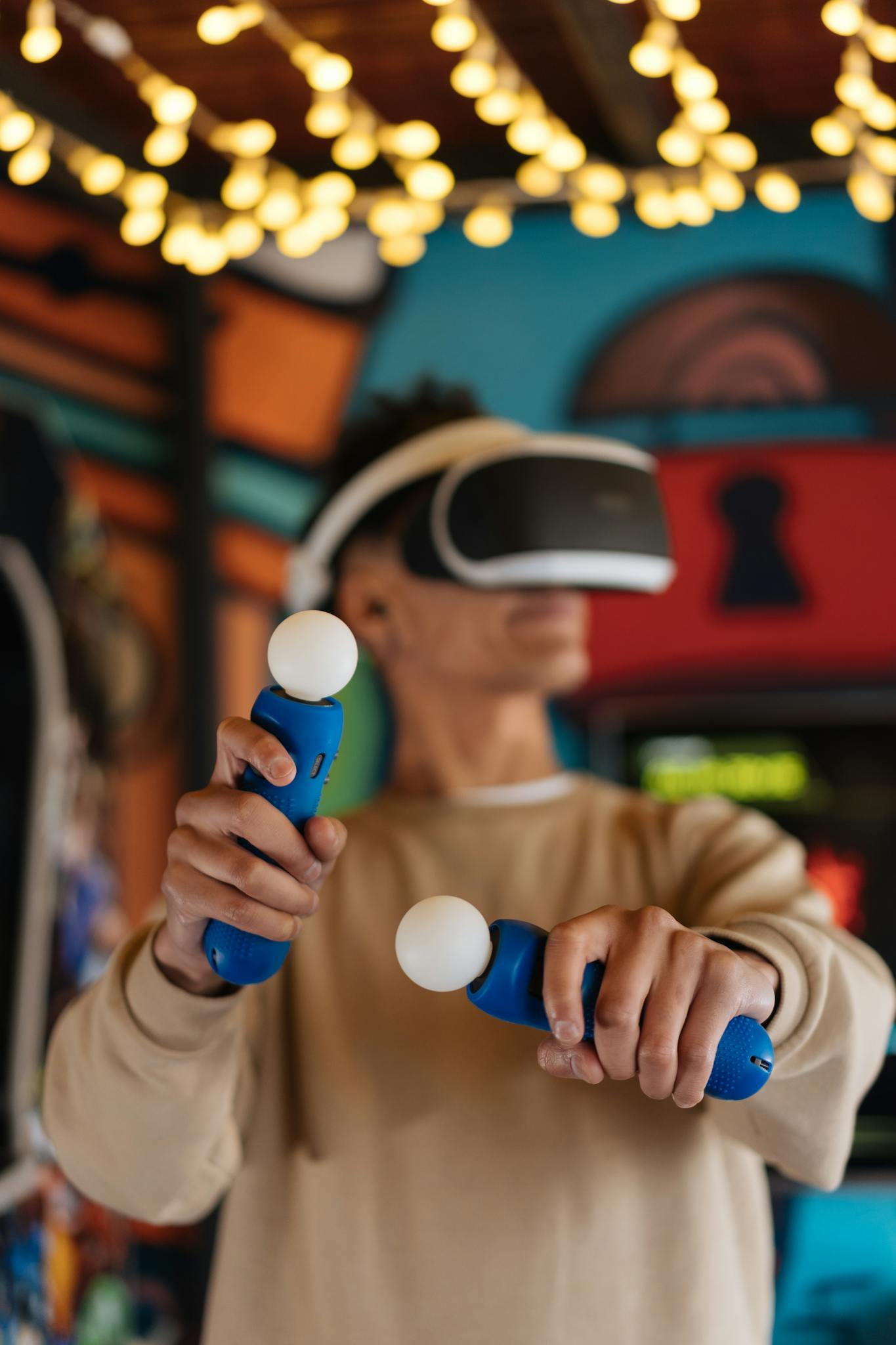 A man using VR headset and controllers in a vibrant gaming environment, fully immersed in virtual reality.